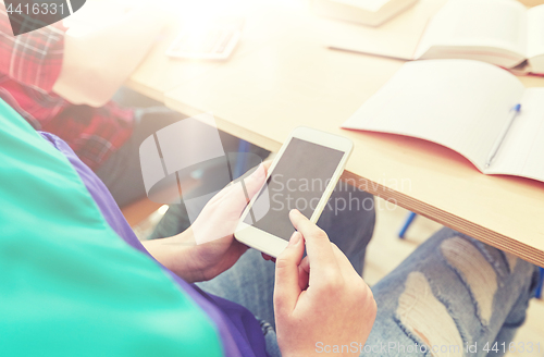 Image of student girl with smartphone texting at school