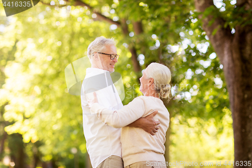 Image of happy senior couple dancing at summer park