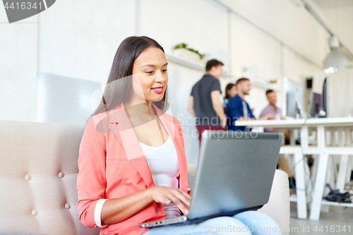 Image of happy woman with laptop working at office