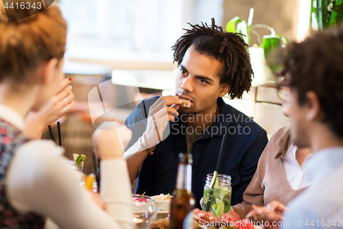 Image of man with friends eating at restaurant