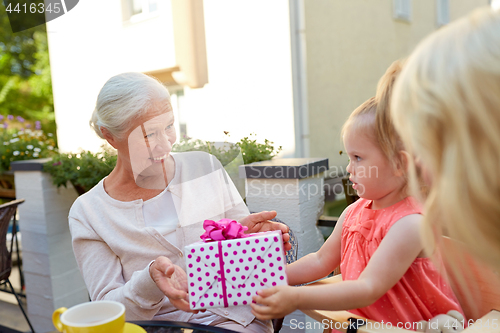 Image of granddaughter giving present to grandmother