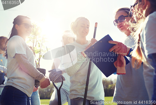 Image of group of volunteers with tree seedlings in park