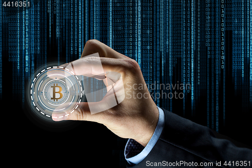 Image of close up of businessman hand with bitcoin hologram