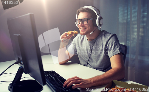 Image of man in headset playing computer video game at home