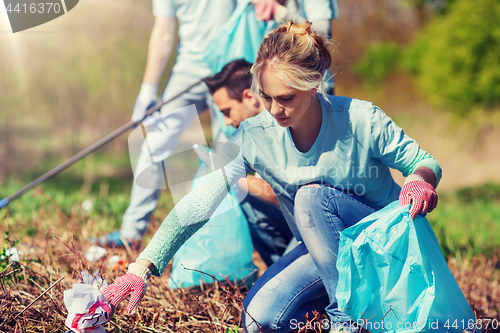 Image of volunteers with garbage bags cleaning park area