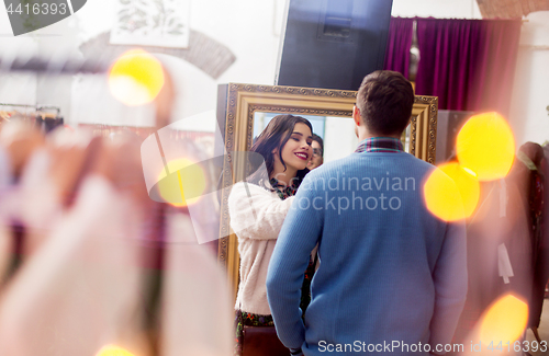 Image of couple choosing clothes at vintage clothing store