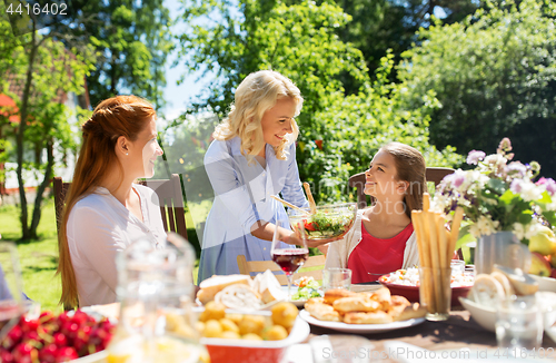 Image of happy family having dinner at summer garden