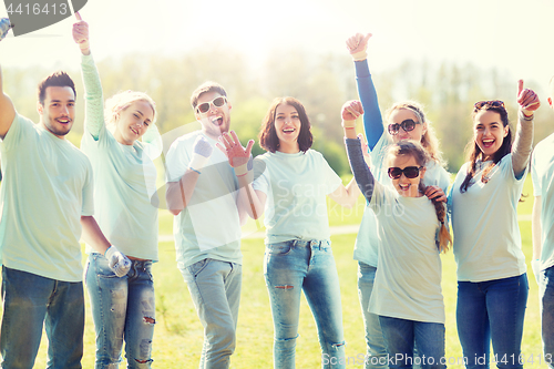 Image of group of volunteers showing thumbs up in park