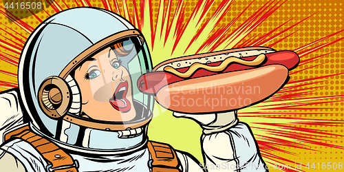 Image of Hungry woman astronaut eating hot dog sausage