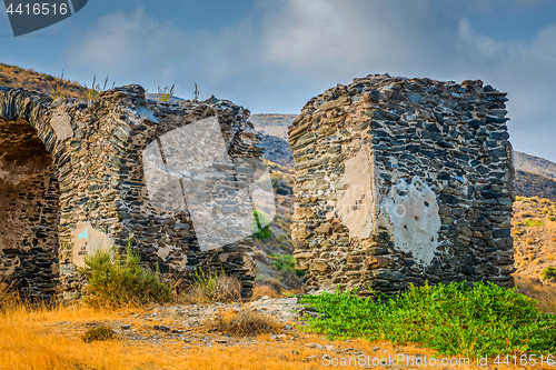 Image of An ancient wall with an arch of stone built in the mountains.
