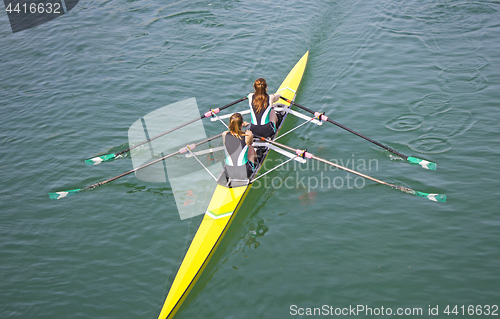 Image of Two young women rowing race in lake