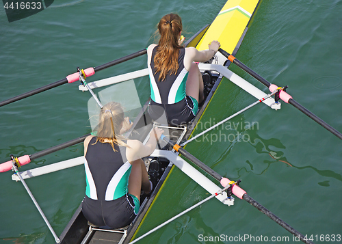 Image of Two young women rowing race in lake