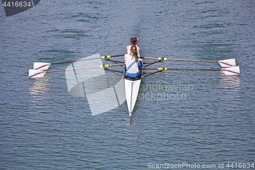 Image of Two young women rowing race in lake