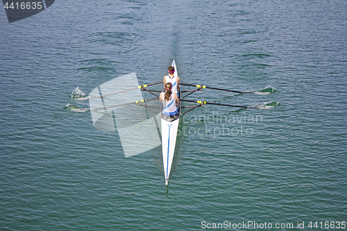 Image of Two young women rowing race in lake