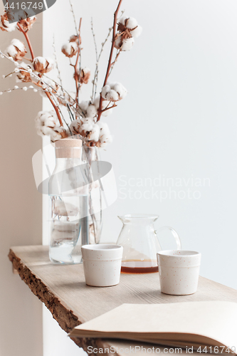 Image of Cup of coffee, branch of tree, wooden windowsill