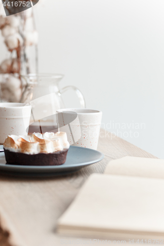 Image of Cup of coffee, branch of tree, wooden windowsill