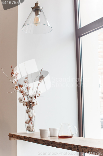 Image of Cup of coffee, branch of tree, wooden windowsill