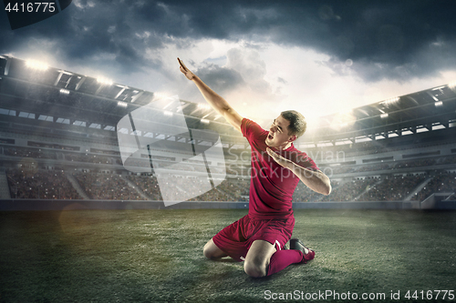 Image of Happiness football player after goal on the field of stadium