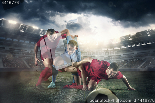Image of The football player in motion on the field of stadium