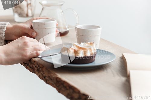 Image of Cup of coffee, branch of tree, wooden windowsill