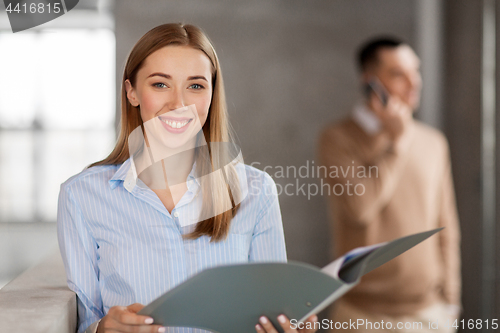 Image of smiling female office worker with folder