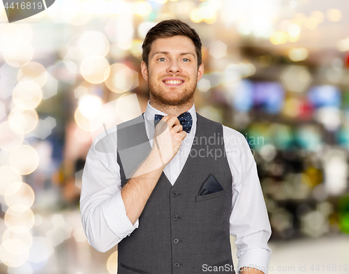 Image of happy man in festive suit over lights