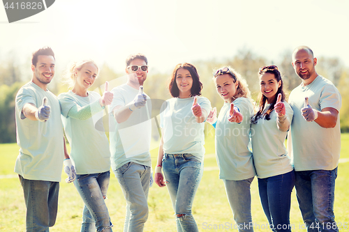 Image of group of volunteers showing thumbs up in park