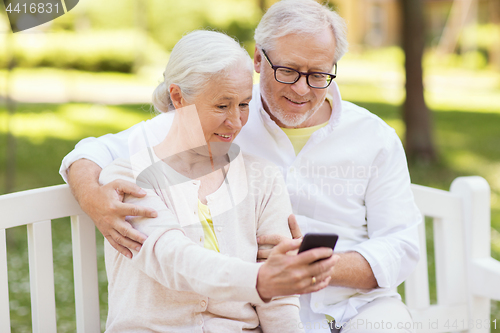 Image of senior couple taking selfie by smartphone at park