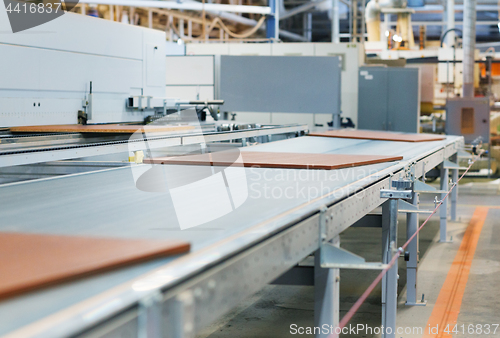 Image of chipboards on conveyer at furniture factory