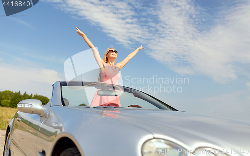 Image of happy young woman in convertible car