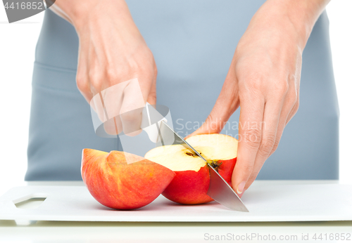 Image of Cook is chopping red apple