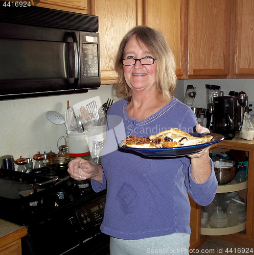 Image of Female cooking pancakes.