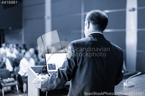 Image of Public speaker giving talk at Business Event.