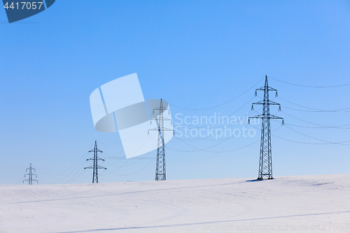 Image of high voltage power lines against a blue sky