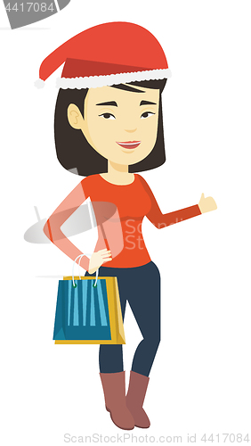 Image of Woman in santa hat shopping for christmas gifts.