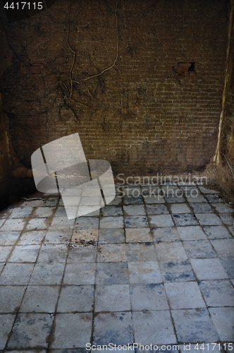 Image of dirty tiled floor and brick wall empty room