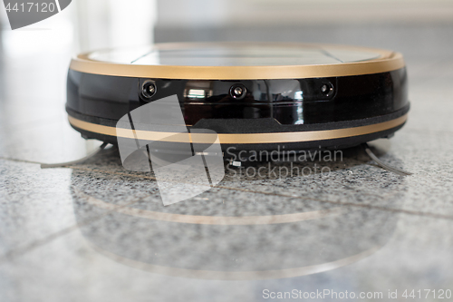 Image of Robotic vacuum cleaner on bright marble floor