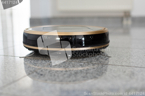 Image of Robotic vacuum cleaner on bright marble floor