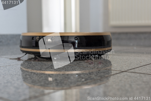 Image of Robotic vacuum cleaner on bright marble floor