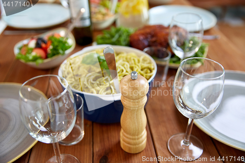 Image of pepper mill or salt grinder on served wooden table