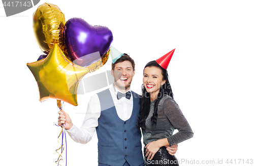 Image of happy couple with party caps and balloons