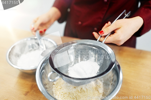 Image of chef with flour in bowl making batter or dough