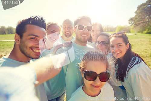 Image of group of volunteers taking selfie by smartphone