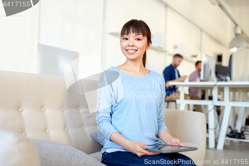 Image of happy asian woman with laptop working at office