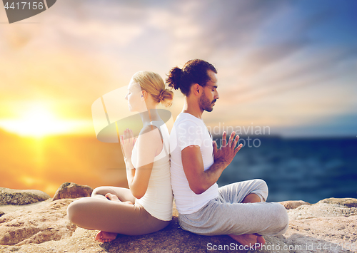 Image of happy couple making yoga and meditating outdoors