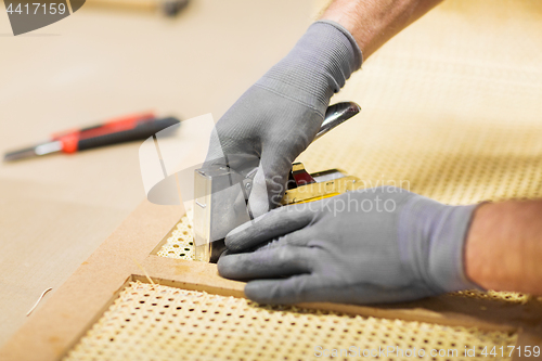 Image of assembler with staple gun making furniture