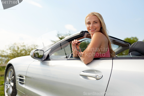 Image of happy young woman in convertible car