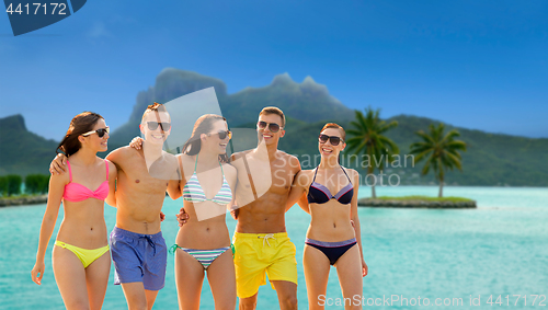 Image of smiling friends in sunglasses on summer beach