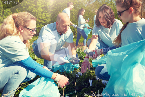 Image of volunteers with garbage bags cleaning park area