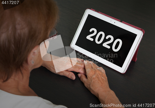 Image of Senior lady relaxing and her tablet - 2020